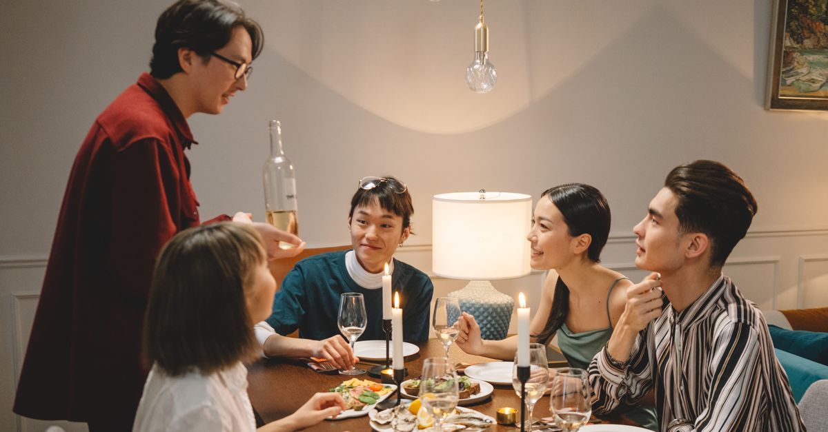 Yemek masasında sohbet eden ve gülüşen bir grup arkadaş